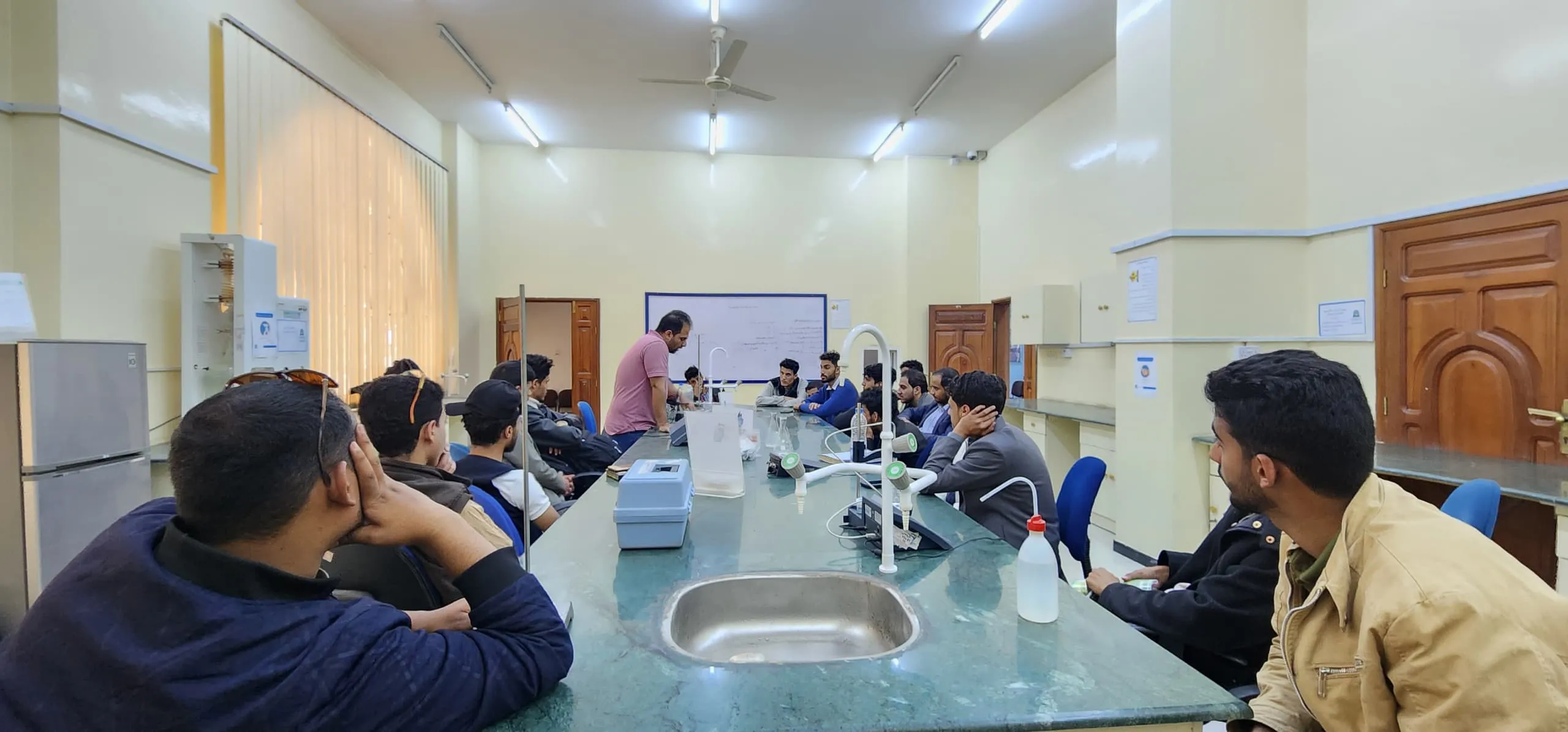 Civil engineering students conduct a practical experiment to measure drinking water quality during a scientific visit to the health laboratory at the University of Science and Technology.